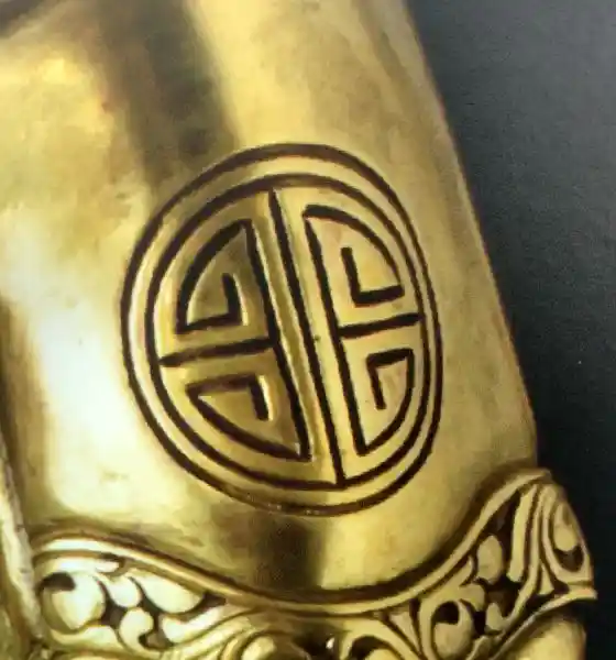 Statue of Buddha with a geometrically derived cross on the arm